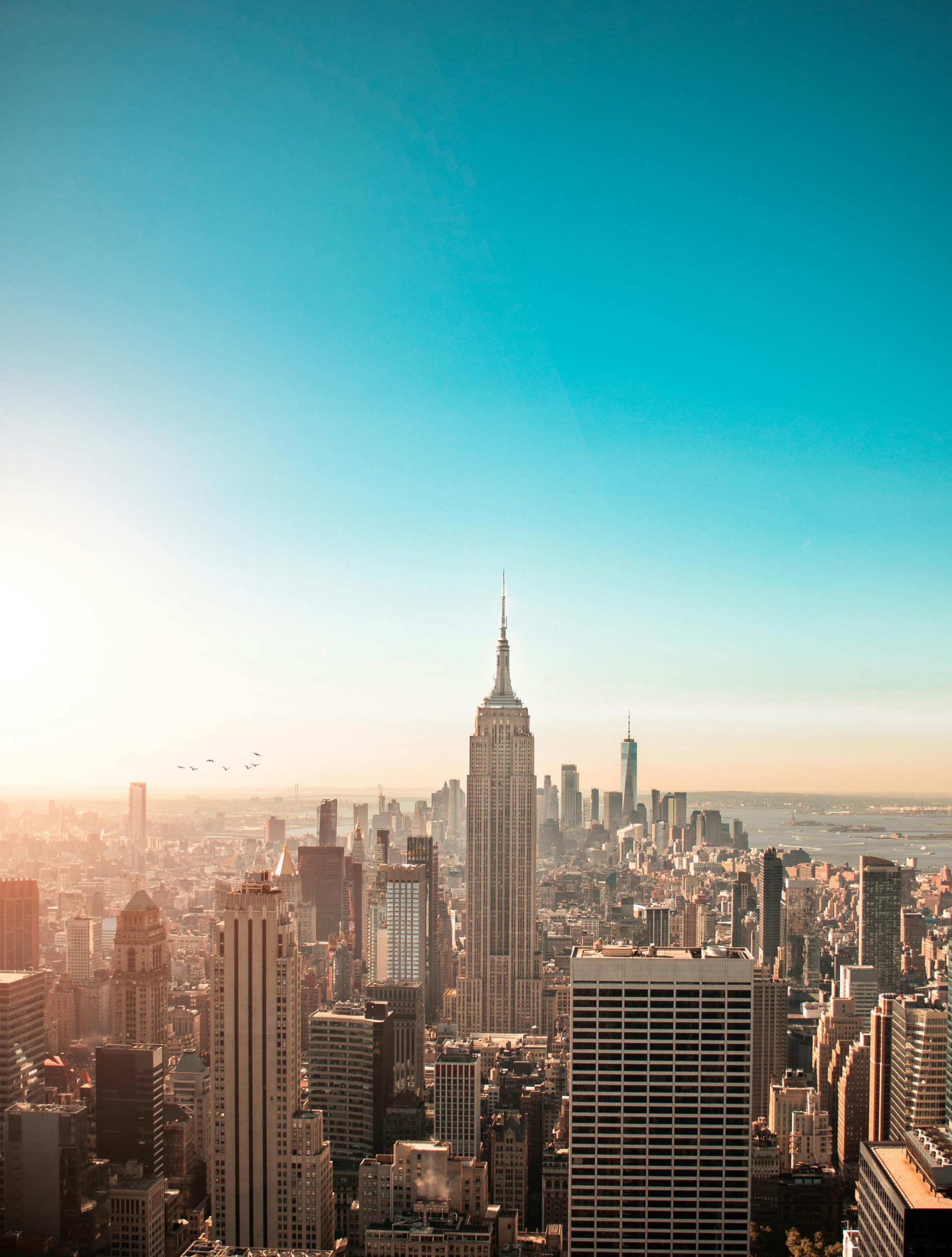 Breathtaking view of New York City's skyline featuring the iconic Empire State Building at sunrise.